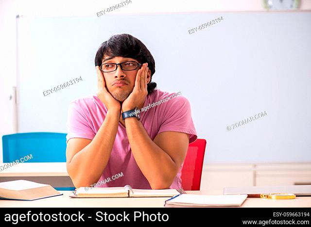 Young male student sitting in the class