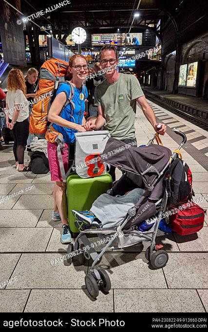 PRODUCTION - 18 August 2023, Hamburg: A couple from Lucerne, Switzerland, stand with their two children on platform 14 in the main station