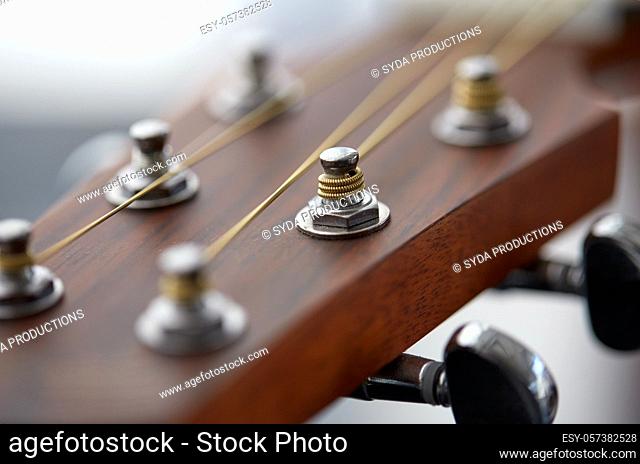 close up of acoustic guitar head with pegs