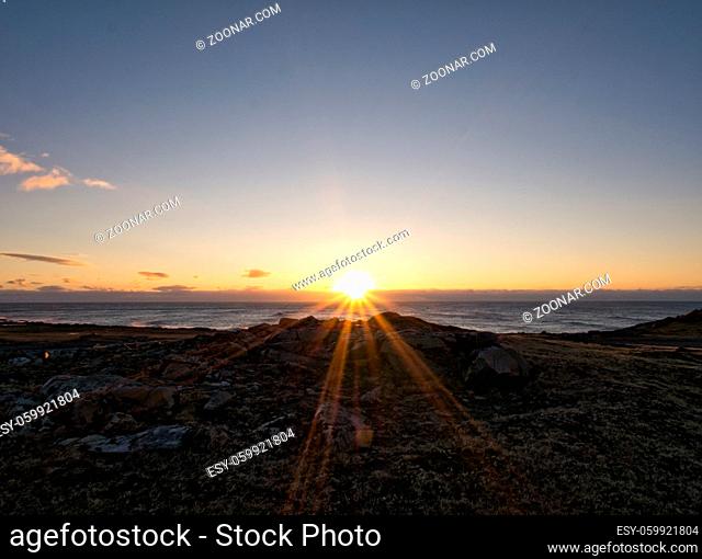 Schöner Blick auf das Meer in Island mit Sonnenuntergang am Horizont