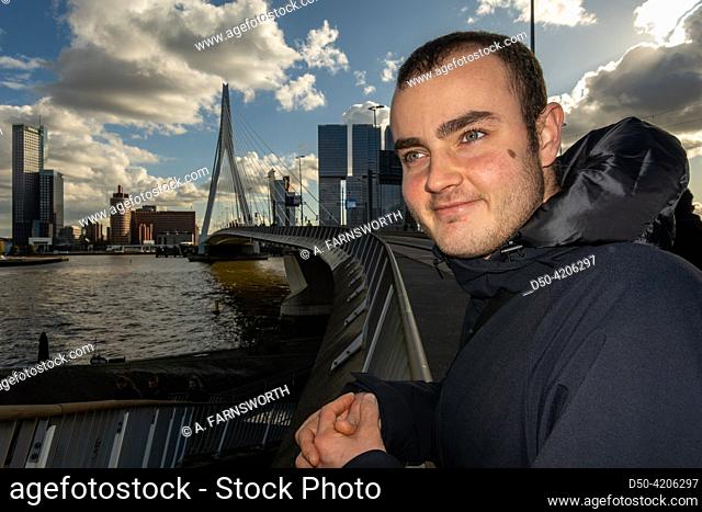 Rotterdam, Netherlands, A young 23 year old man stands on the Erasmus Bridge in downtown