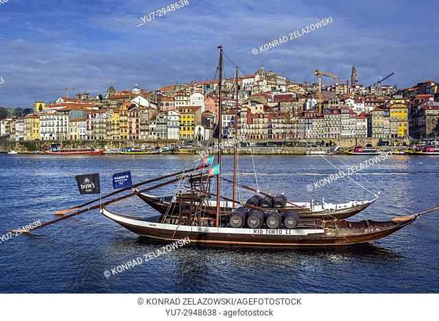 Dow's and Warre's Port wine boats called Rabelo Boats on a Douro River in Vila Nova de Gaia city. Porto city river bank on background