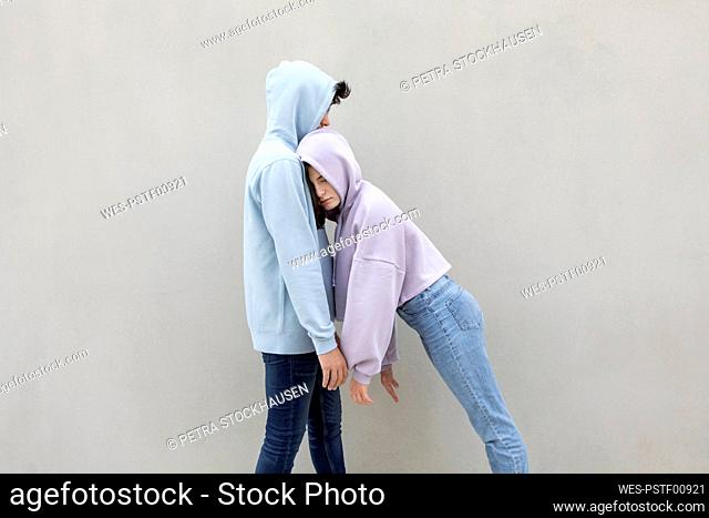 Girl with eyes closed leaning on boyfriend by wall