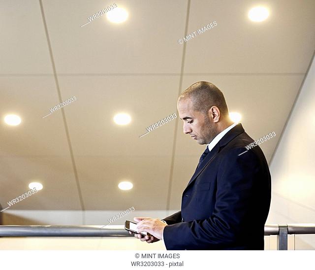 A middle eastern businessman working on a notebook computer standing in an office lobby