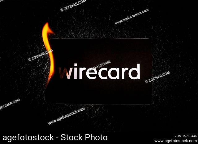 Madrid, Spain - June 27, 2020: Wirecard prepaid card burning on fire following the company bankruptcy and the freezing of cardholders' money, financial collapse