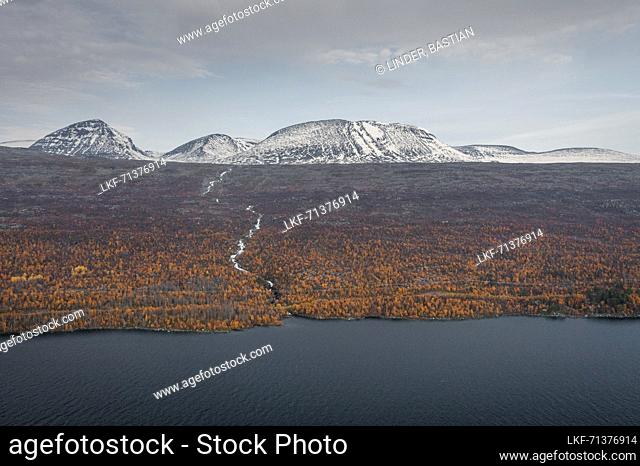 Landscape with snowy mountains and river to the lake in Stora SjÃ¶fallet National Park in autumn in Lapland in Sweden