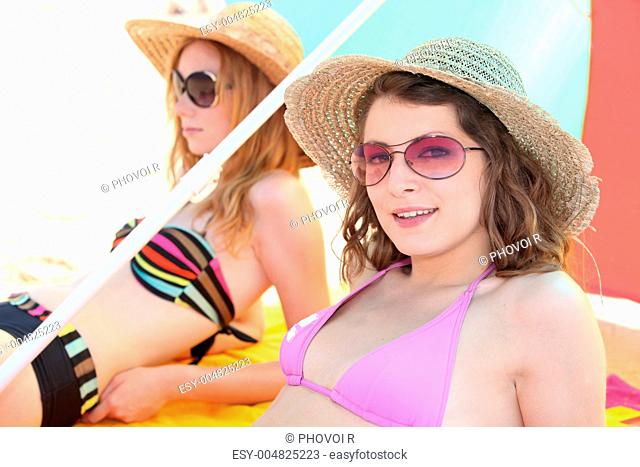 Two girls sunbathing at the beach