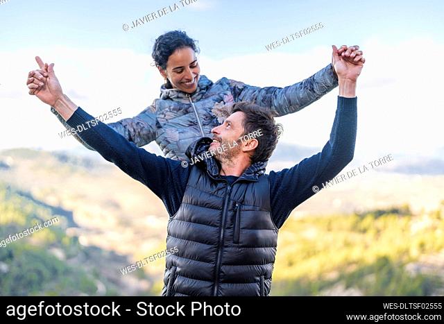 Happy couple looking at each other standing with arms outstretched