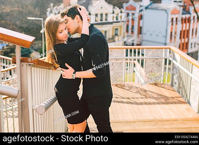 Beautiful young multiracial couple, a couple of students walk on the stairs in Kiev in the city center. Handsome Turkish brunette guy hugging