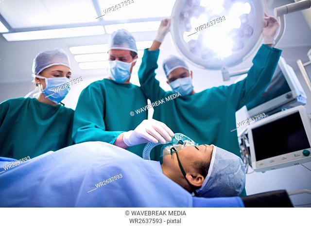 Surgeons adjusting oxygen mask on patient mouth in operation theater
