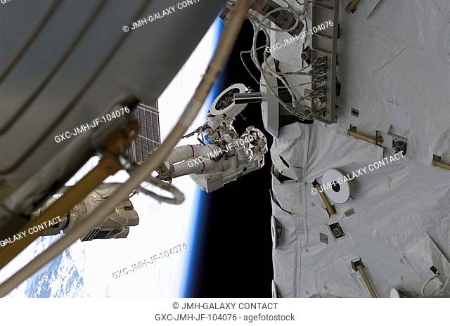 Astronaut Franklin R. Chang-Diaz works with a grapple fixture during extravehicular activity (EVA) to perform work on the International Space Station (ISS)