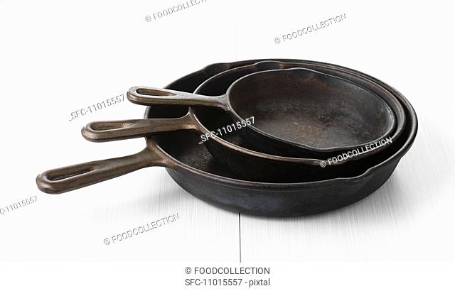 Three iron pans in different sizes