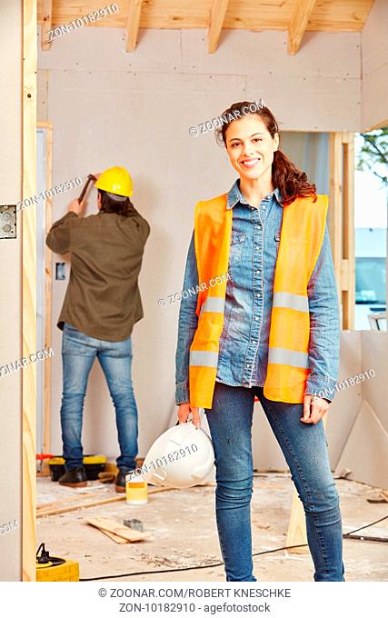 Junge Frau in der Handwerker Lehre arbeitet auf einer Baustelle