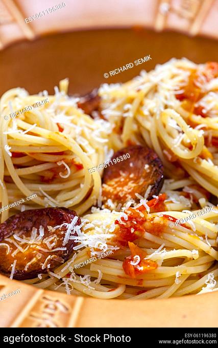 spaghetti with sausage and tomatoes and parmesan cheese