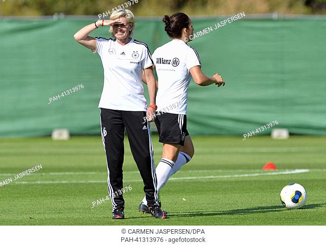Germany's head coach Silvia Neid (L) and Nadine Kessler take part in a training session with the German national women's soccer team in Stockholm, Sweden