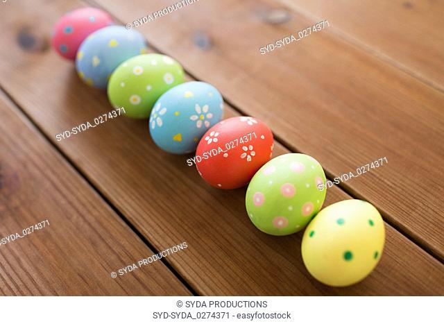 row of colored easter eggs on wooden table