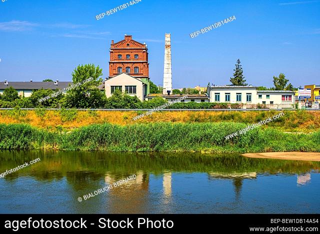 Konin, Greater Poland province / Poland - 2019/06/26: Historic industrial buildings over the Warta river, at the Nadbrzezna street in the historic quarter of...