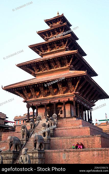 Bhaktapur, Nepal - December 4, 2014: People sitting on steps of Nyatapola Pagoda on Taumadhi Sqaura