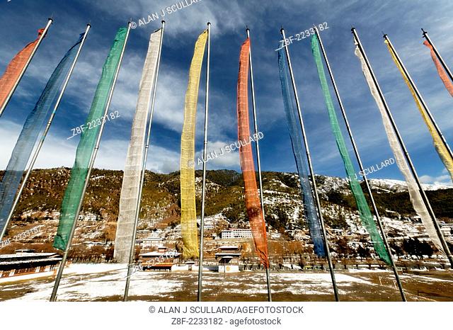 A row of Buddhist prayer flags on flagpoles in the Bhutanese capital, Thimpu. Digitally Manipulated Image. Stylised by enhancing color
