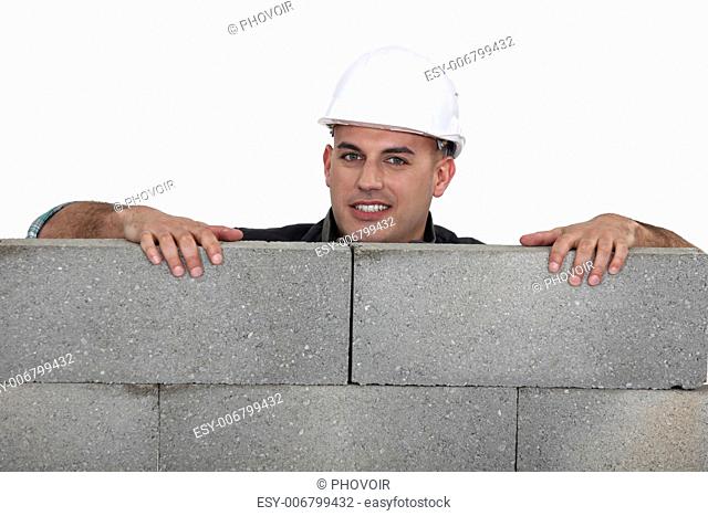 Mason behind a brick wall