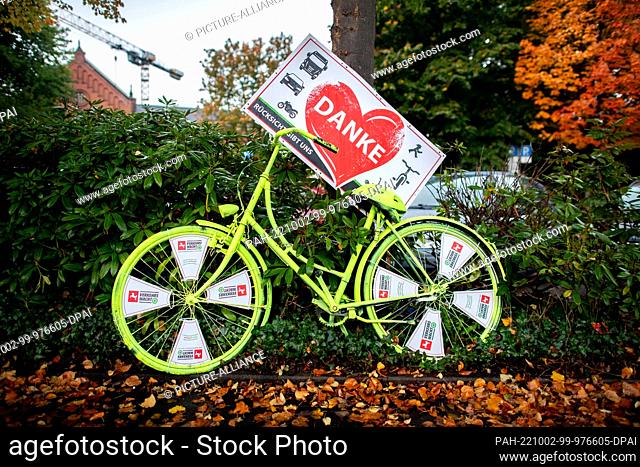 02 October 2022, Lower Saxony, Oldenburg: A neon-yellow bicycle belonging to the Lower Saxony traffic watch group, with a sign reading ""Thank you -...