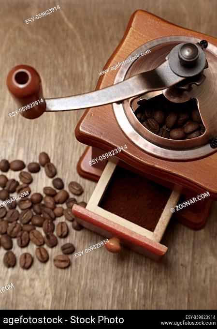 vintage coffee grinder and beans on old wooden background