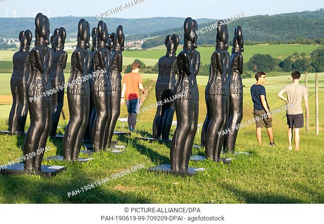 17 June 2019, Hessen, Glauburg: Plastic replicas of the Celtic prince of the artist Ottmar Hörl stand in front of the Museum Keltenwelt am Glauberg