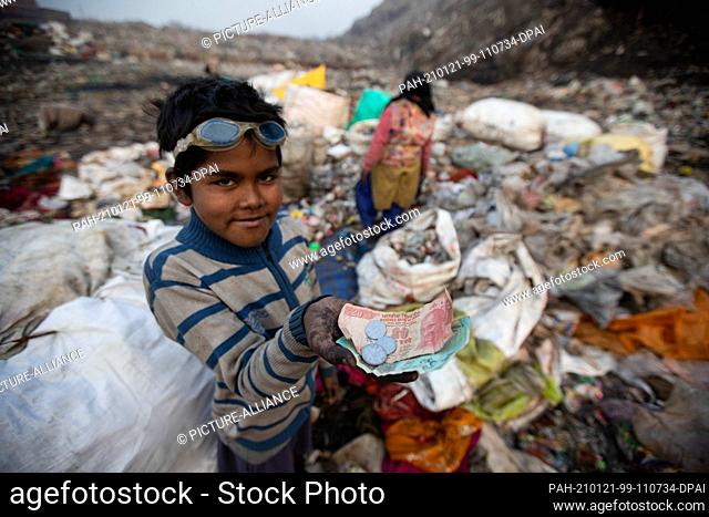 18 January 2021, India, Neu Delhi: Ten-year-old Shekh Zahid shows the money he earned after selling recyclable items while collecting garbage at the Bhalswa...