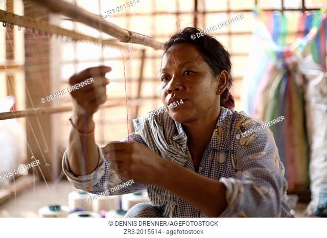 A women works in a small village textile factory outside of Phnom Penh, Cambodia