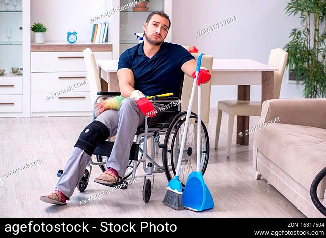 Young leg injured contractor in wheelchair cleaning the house