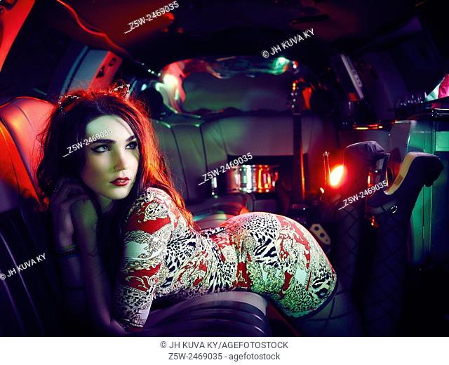 Attractive brunette girl posing inside the limousine