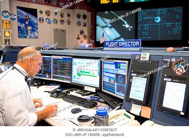 Expedition 40 flight director Tony Ceccacci monitors in-space operations in this view of the activity in the space station flight control room (FCR-1) during...