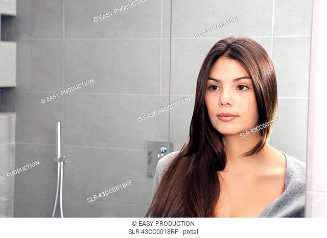 Woman examining herself in mirror