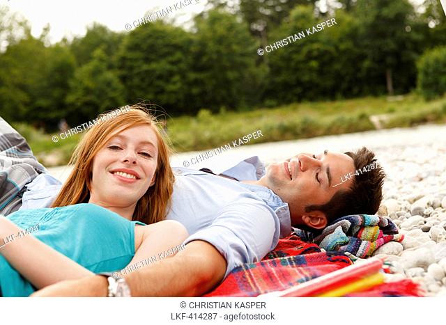 Young couple on bank of Isar river, Munich, Bavaria, Germany