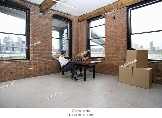 Couple sitting in an empty loft apartment