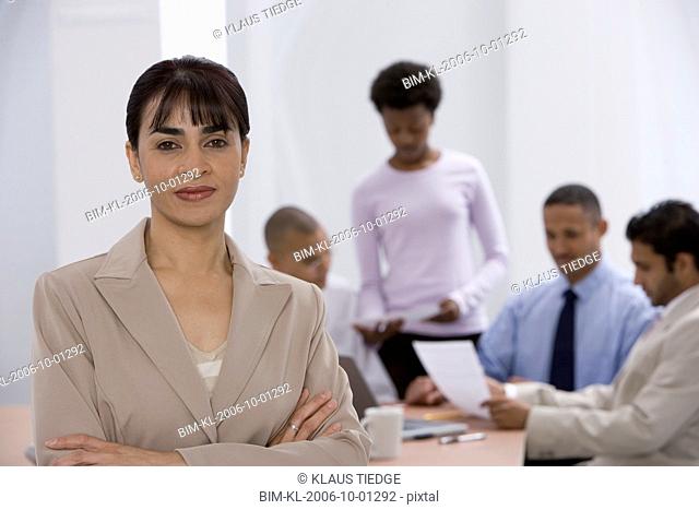 Indian businesswoman with co-workers in background