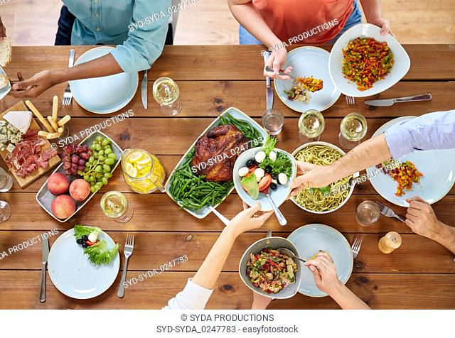 group of people eating at table with food