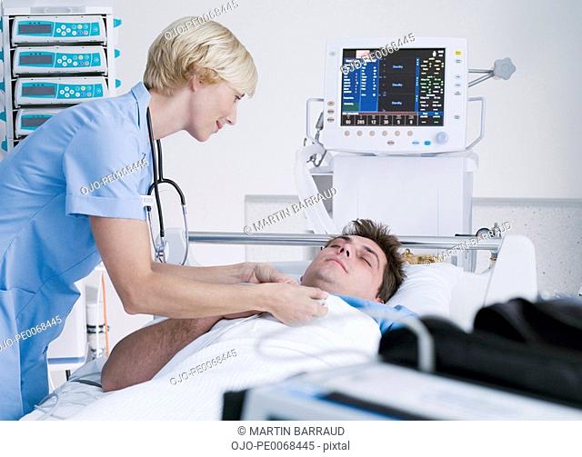 Nurse tending patient in intensive care
