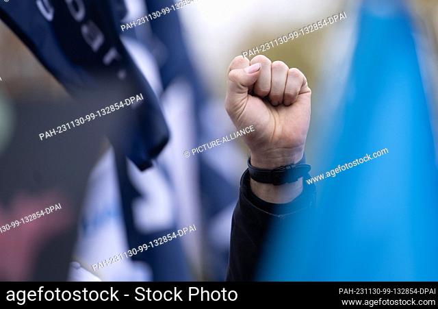 30 November 2023, Baden-Württemberg, Stuttgart: A participant at a rally as part of protest actions in the public sector wage dispute clenches his fist