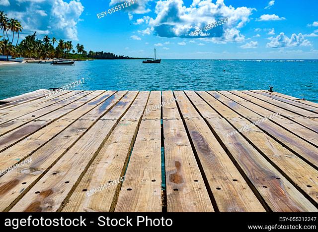 wooden batten bridge juts out into the expanse of the sea Dominican Republic