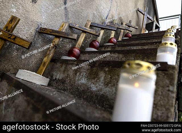 23 July 2023, North Rhine-Westphalia, Duisburg: Candles and crosses stand on a staircase in memory of the victims of the Love Parade disaster