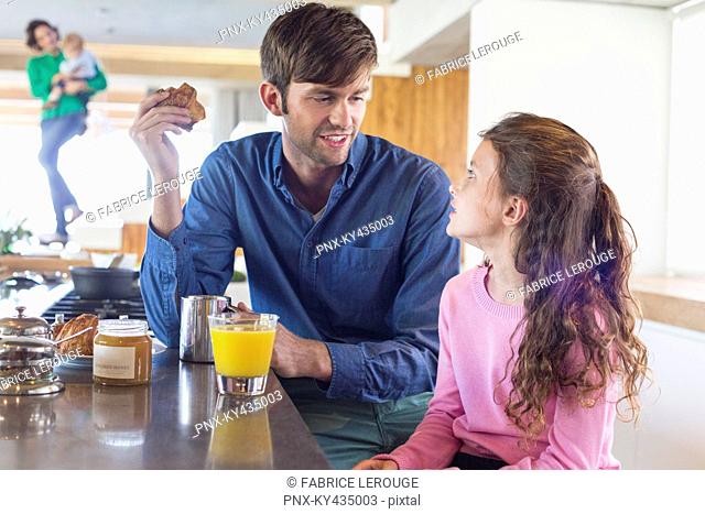 Man having breakfast with her daughter at a kitchen counter