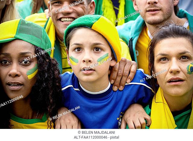 Brazilian football supporters watching match attentively