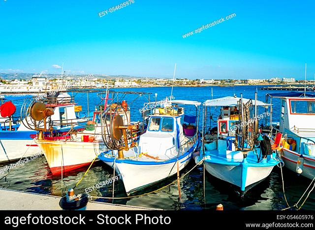 Typical colorful fishing boats moored in Paphos city harbor, sunlight, Cyprus