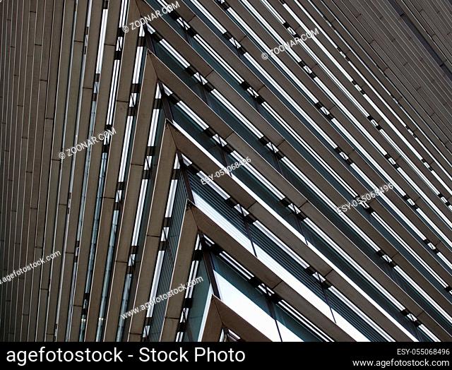 close up detail of the corner of a large modern office building with geometric metallic steel lines