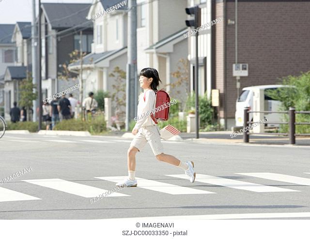 A girl walking on the pedestrian crossing