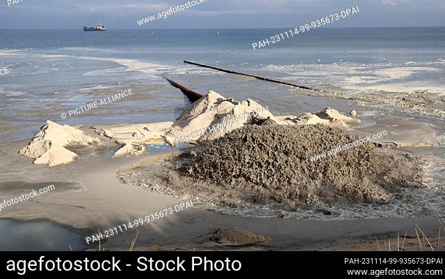 PRODUCTION - 13 November 2023, Mecklenburg-Western Pomerania, Prerow: The water-sand mixture for sand replenishment shoots out of a pipe on the beach