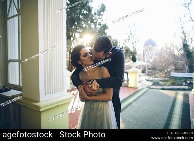 Newlywed couple embracing at terrace