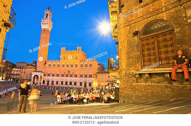 On background Torre del Mangia tower and Palazzo Pubblico town hall, from Costa dei Barbieri, Piazza del Campo, Siena's premier square, Siena