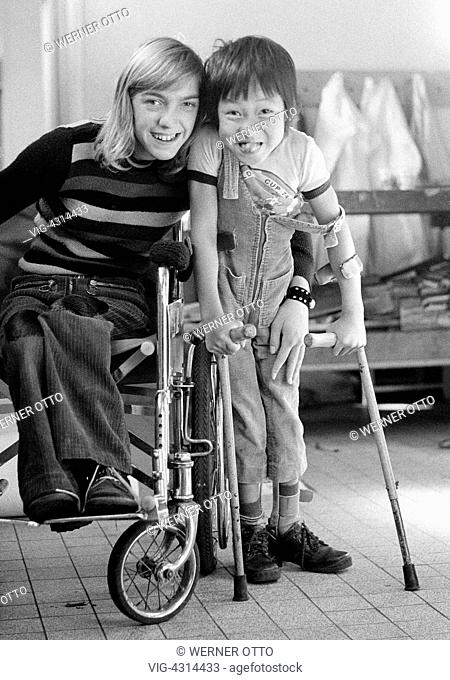 DEUTSCHLAND, OBERHAUSEN, STERKRADE, 14.09.1973, Seventies, black and white photo, people, physical handicap, girl in a wheel-chair and boy from Vietnam with...